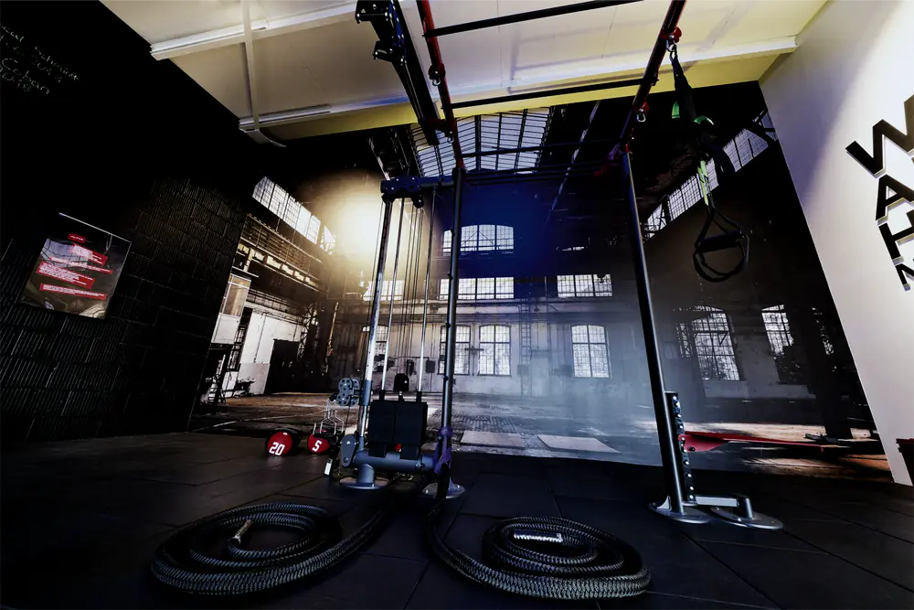 Functional-Rig mit Kabelzug, Schlingentrainer und Battle Ropes vor einer Fototapete mit Industriehalle