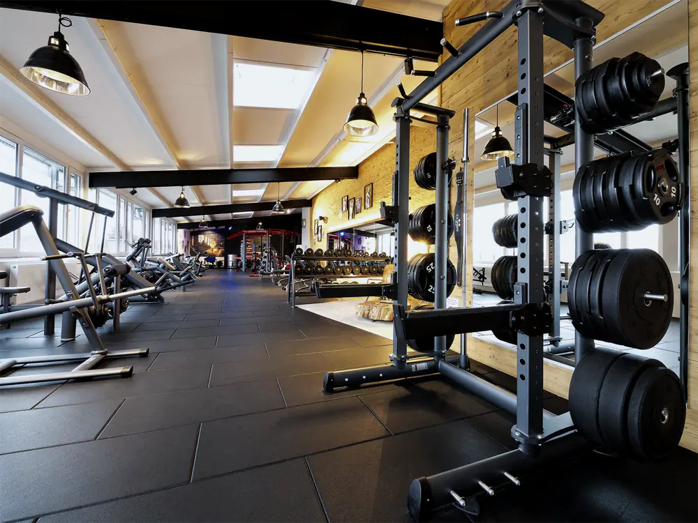 Power Rack mit Hantelscheiben und freie Gewichte im Kraftwerk Donaueschingen, links eine Reihe Kraftmaschinen, im Hintergrund das Kurzhantelregal